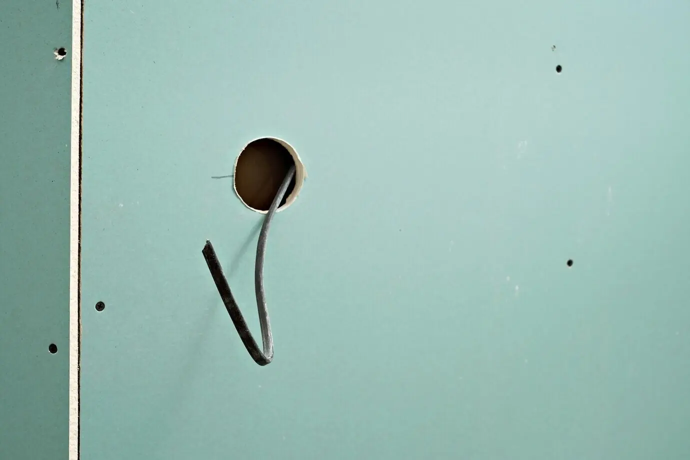 Vorbereitung zur Installation einer Steckdose oder eines Schalters. Loch in der Gipskartonwand zur Montage einer Steckdose oder einer neuen Lampe. Reparatur und Bau.